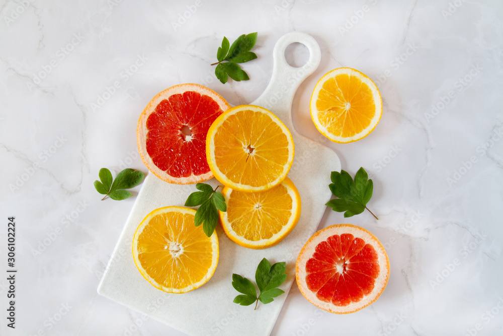 Oranges flatlay. Beautiful healthy summer background. Fresh fruits sliced on a white marble table. Oranges flatlay. Beautiful healthy summer background. Fresh fruits sliced on a white marble table.