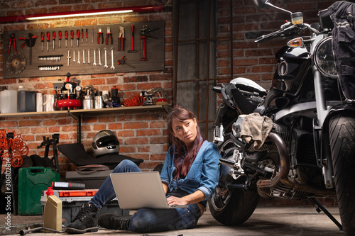 Female mechanic checking for motorbike parts