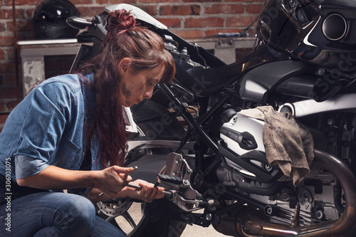 Female mechanic working on a vintage motorbike