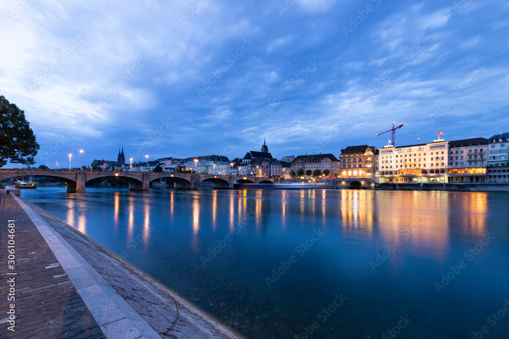 Switzerland, Basel, Unterer Rheinweg, 27 July 2019. Panoramic view across the rhine river at the skyline of the old town of Basel during sunrise.