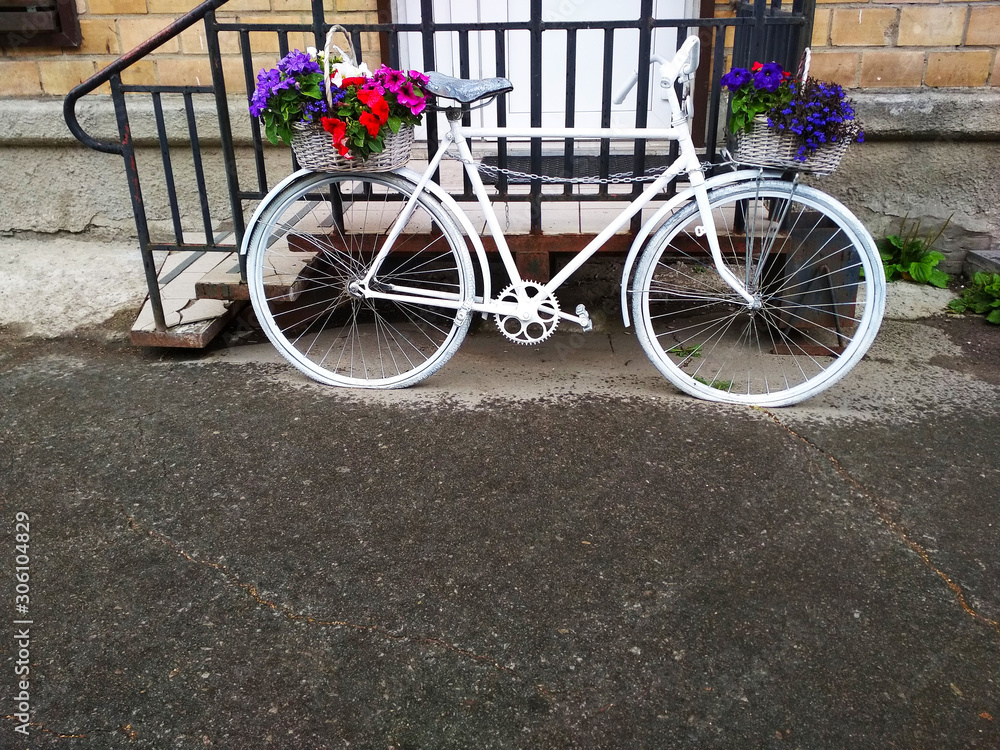 .A vintage two-wheeled Bicycle with flowers on it.