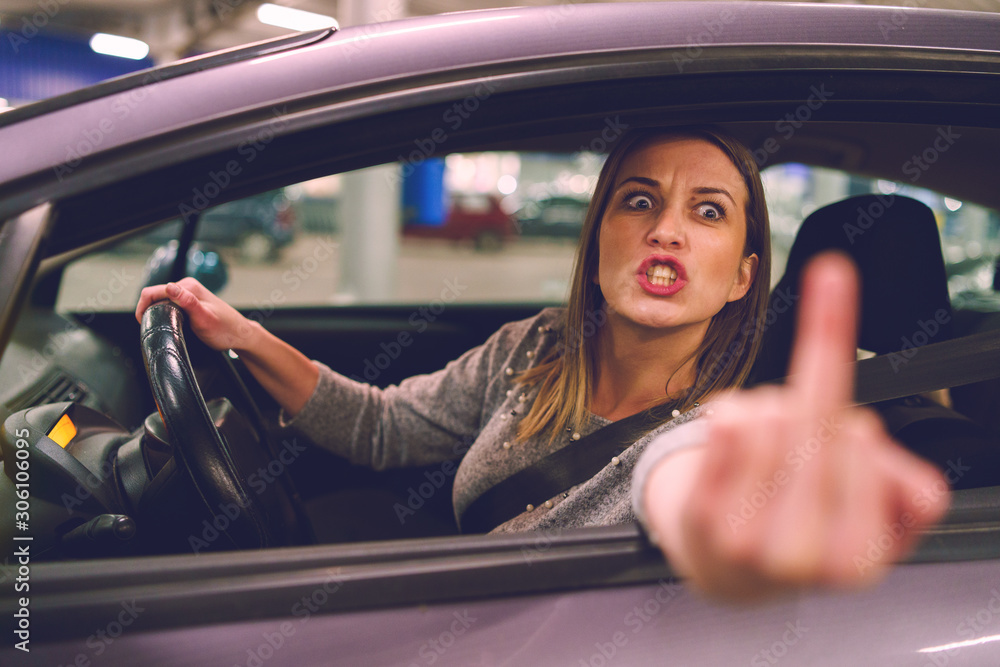Beautiful lady showing middle finger from her car Photos