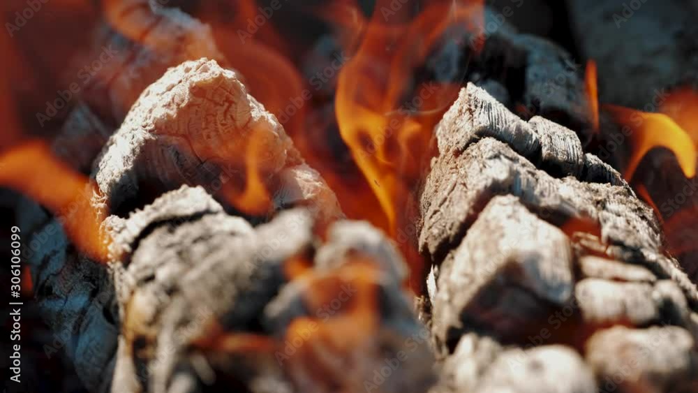 Slow motion of colorful burning flame in campfire. Close up of burning firewoods and coals. Tongues of fire on logs, ashes are flying Slow motion of colorful burning flame in campfire. Close up of burning firewoods and coals. Tongues of fire on logs, ashes are flying