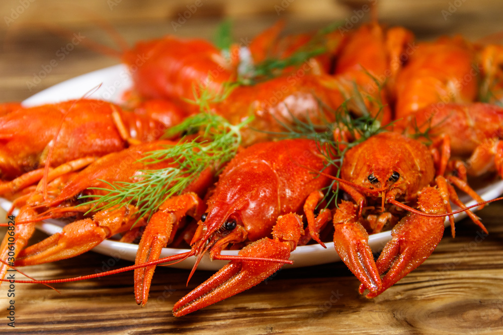Boiled crayfish in plate on wooden table Boiled crayfish in plate on wooden table