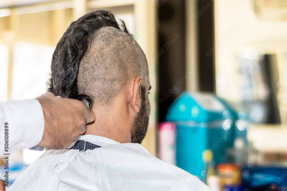 a young man is trimming his half head shaved a young man is trimming his half head shaved