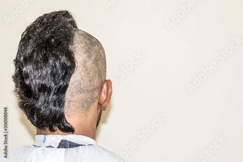 a young man is trimming his half head shaved