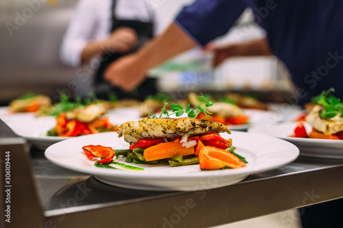 Cooking a delicious main course in the restaurant kitchen. Catering on holiday. photo