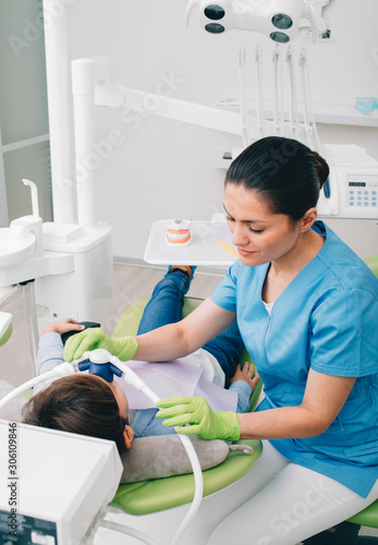 Foto Pediatric dentist doing Inhalation Sedation to a child while teeth treatment at dental clinic