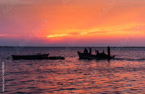 Red sky and fishermen. Fishermen are leaving at sunset.