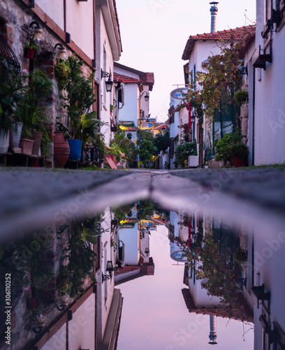 Reflection of narrow street in water. Slow city Izmir Seferihisar. Reflection...