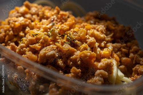 Pasta with minced meat and onion in navy-style on a gray background.