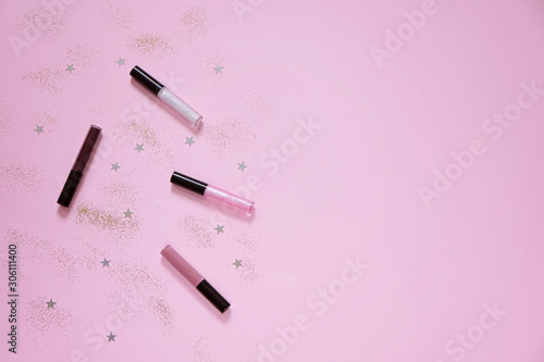 Flat lay with lip balm on pink background with space for text