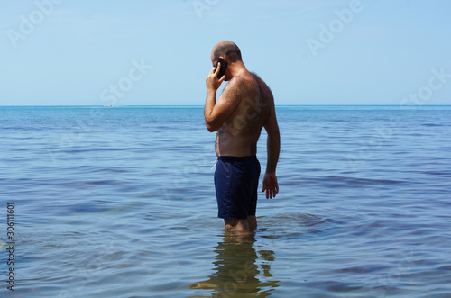 A man at sea talking on the phone.
