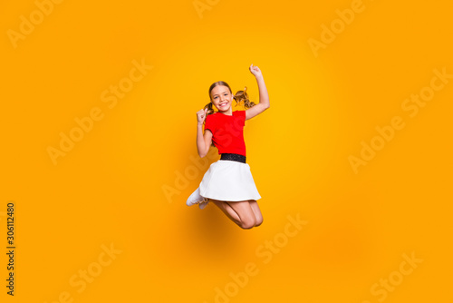Full length photo of pretty little lady pretty long tails jumping high amazing good mood rejoicing weekend wear casual red white dress isolated yellow color background