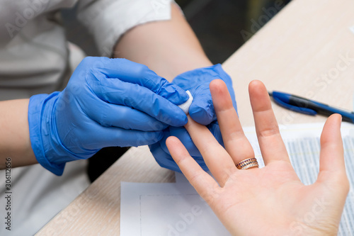a doctor prepares a patient s finger for blood sampling