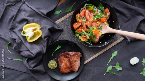 medium beef steaks with pesto sauce and vegetable salad. 