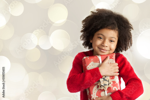 Christmas concept. Happy adorable african american child girl with christmas gift in hands isolated on white background.