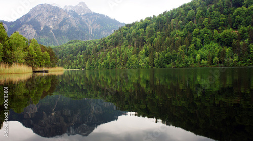 Ein Bergsee mit Wald, der sich im Wasser spiegelt photo
