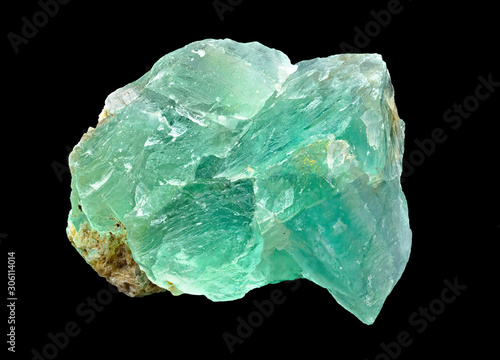 Green translucent fluorite rough mineral stone on a black background