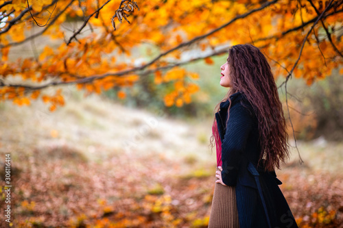 Portrait of a beautiful hispanic young woman in an autumnal forest