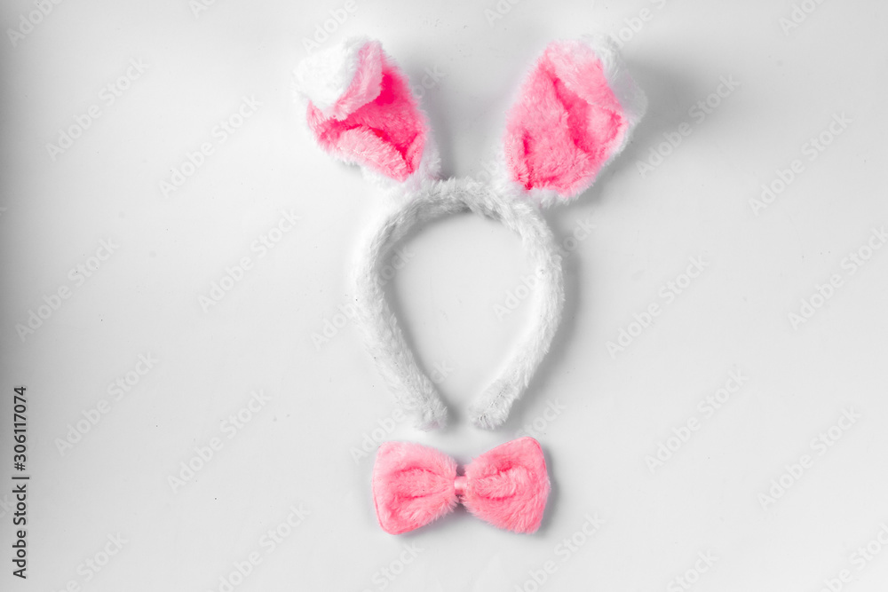 Top view of cute bunny ears with a small pink bow on wooden background. Top view of cute bunny ears with a small pink bow on wooden background.
