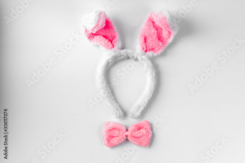 Fototapeta Naklejka Na Ścianę i Meble -  Top view of cute bunny ears with a small pink bow on wooden background.