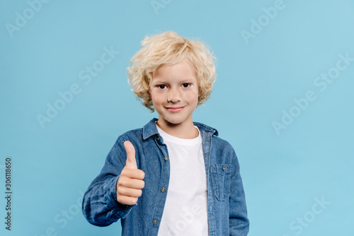 smiling and cute kid looking at camera and showing like isolated on blue