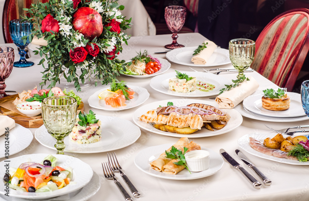 Served for holiday banquet restaurant table with dishes, snack, salads,  cutlery, wine and water glasses. European food in a restaurant setting.  Table set for an event party. catering Photos | Adobe Stock