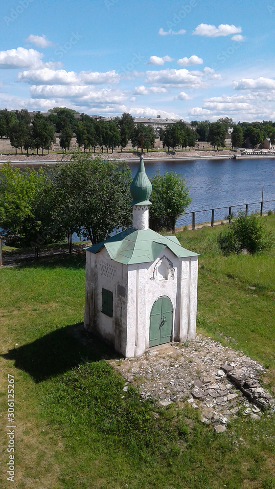 Chapel of St. Anastasia in Pskov. At the Great River. Panorama of the architectural structure. Historic building with a dome and a cross. View from the height of the Olga bridge. Cloudy landscape. 