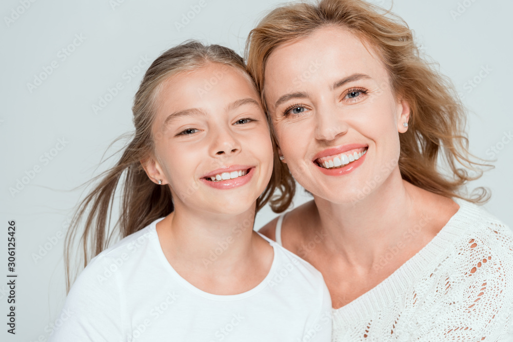 attractive and smiling mother and daughter looking at camera isolated on grey attractive and smiling mother and daughter looking at camera isolated on grey