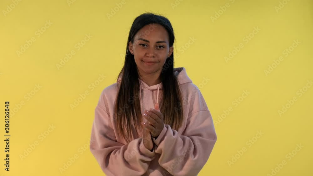 Portrait of smiling black lady giving applause to somebody on yellow background. She clapping her hands. Portrait of smiling black lady giving applause to somebody on yellow background. She clapping her hands.