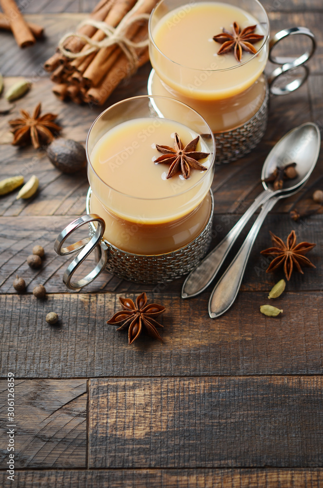 Indian masala chai tea. Spiced tea with milk in vintage cups on the rustic wooden table. Indian masala chai tea. Spiced tea with milk in vintage cups on the rustic wooden table.