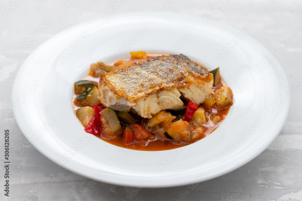 cod fish with vegetables in white plate