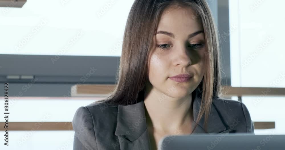 Concerned woman working on laptop computer and looking away thinking solving problem at office. Serious attractive female working with notebook Concerned woman working on laptop computer and looking away thinking solving problem at office. Serious attractive female working with notebook