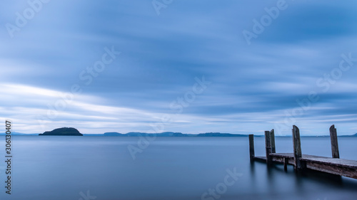 Long exposure of a wooden pier with dramatic sky on Lake Taupo New Zealand