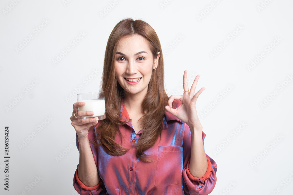 Healthy Asian woman drinking a glass of milk show OK sign. Healthy Asian woman drinking a glass of milk show OK sign.