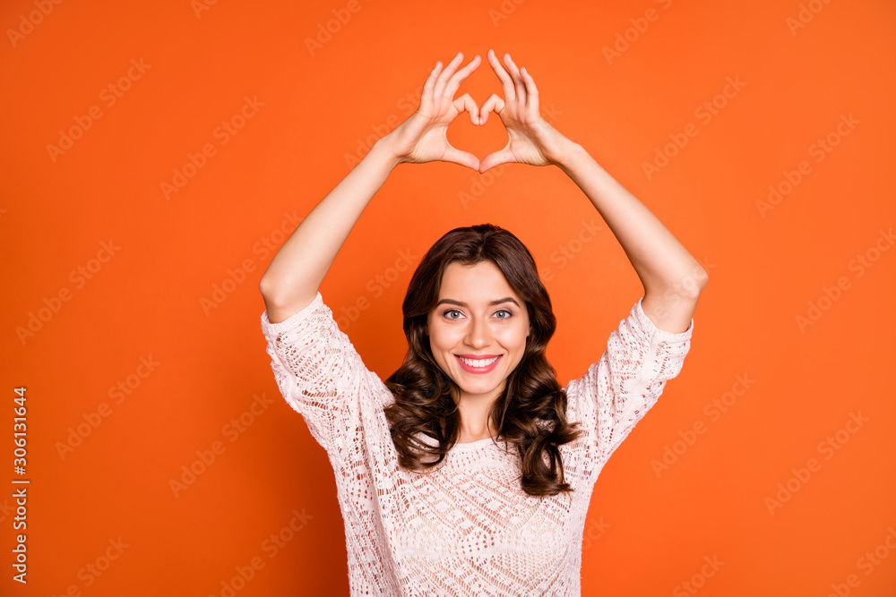 Naklejka premium Portrait of lovely charming girl date with her boyfriend make heart figure finger show passionate love sign wear good looking clothing isolated over orange color background