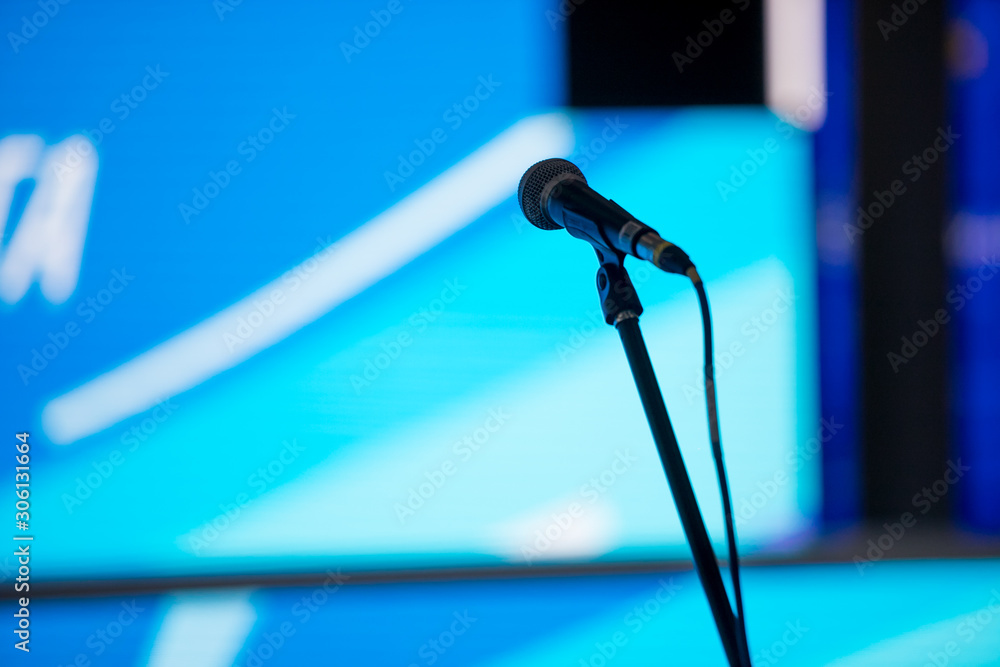 Microphone in the conference hall or seminar room background. meeting room, seminar, event, business, hall, presentation, exhibition Microphone in the conference hall or seminar room background. meeting room, seminar, event, business, hall, presentation, exhibition