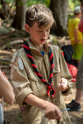 boy scout with a pocket knife in the forest photo