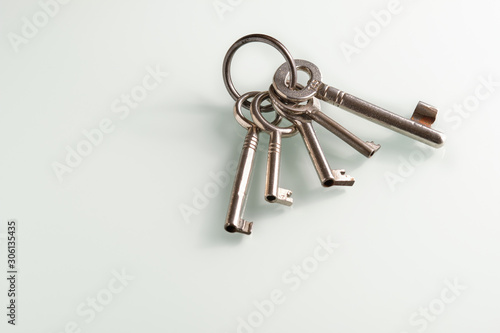 Slika na platnu Closeup of a bunch of old keys lying on a white glass plate