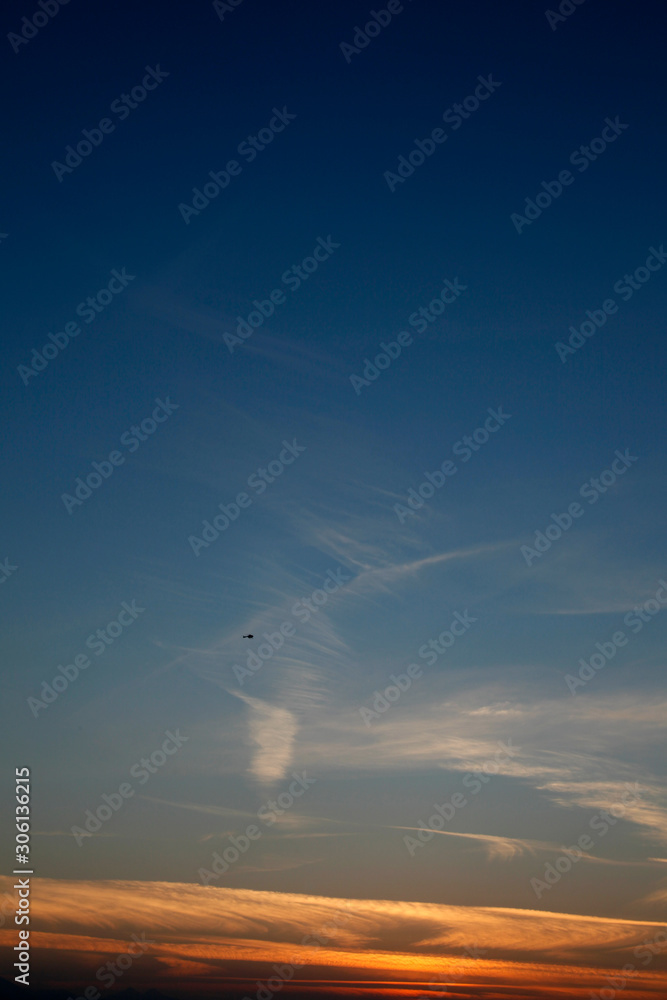 Obraz premium a vibrant blue and golden sunset in the swirling clouds of the izmir-Turkiye