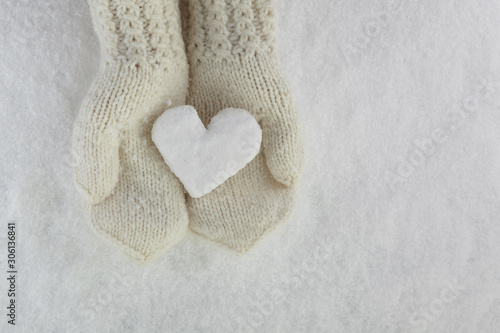Snow Heart in Hands with Mittens on white snow background