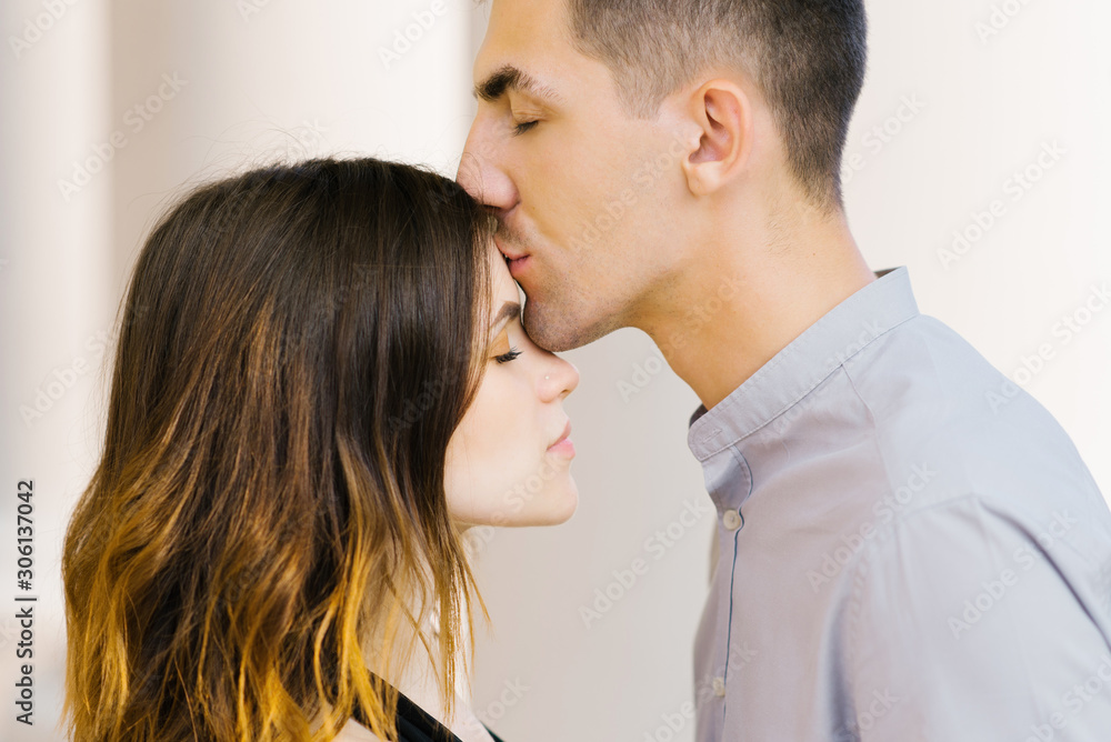 Kiss a beautiful couple in love on the forehead. Valentine's day Kiss a beautiful couple in love on the forehead. Valentine's day