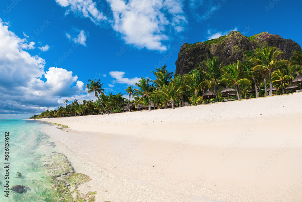 Beautiful view of tropical resort on Mauritius. Sand, palms, mountain and sky Beautiful view of tropical resort on Mauritius. Sand, palms, mountain and sky