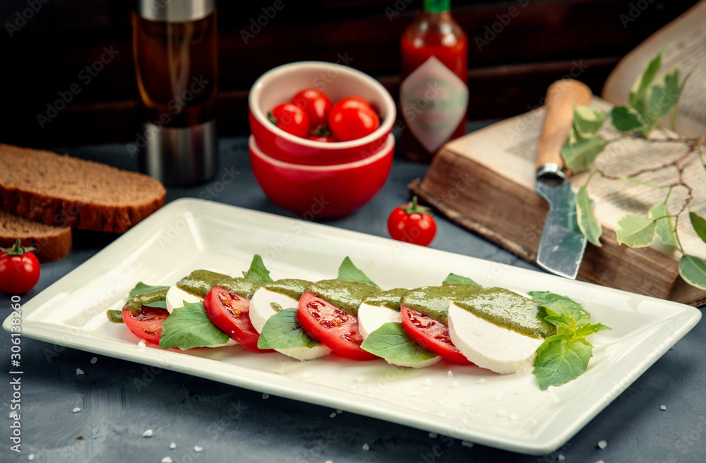 sliced white cheese and tomato in leaves