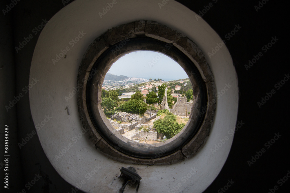 Fototapeta premium Views of an ancient city from a round window