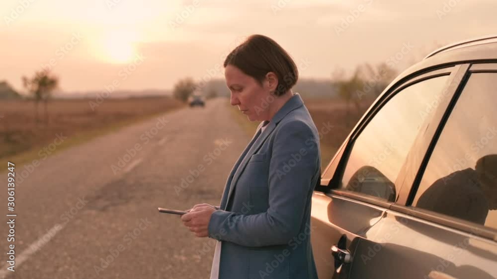 Woman text messaging roadside assistance help after car broke down