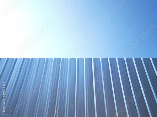 Silver galvanized walls and bright blue skies Along with the sun light on the blue sky background With copy space