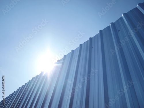 Horizontal silvery galvanized walls and bright blue skies Along with the sun light on the blue sky background With copy space