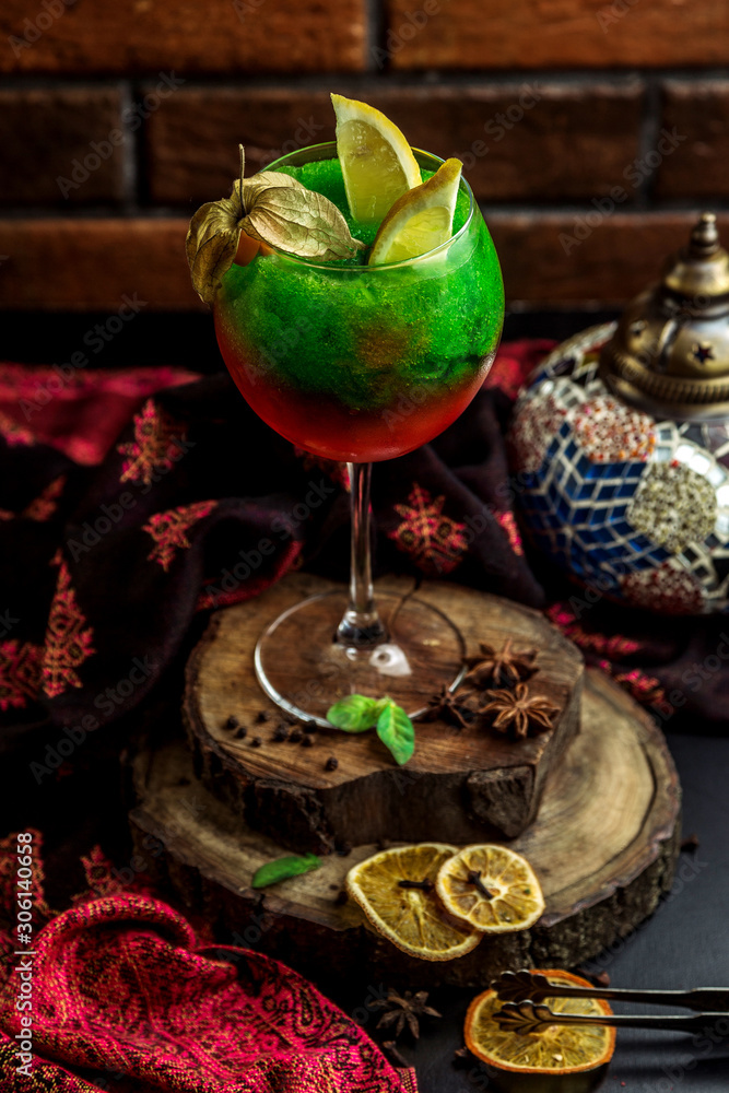 red and green cocktail topped with lemon